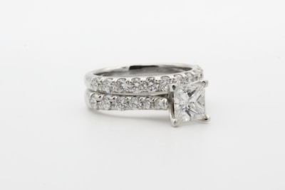silver diamond ring on white surface