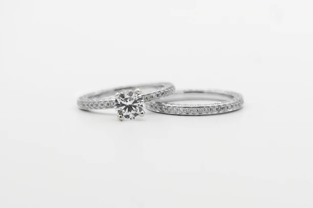 silver diamond studded ring on white surface