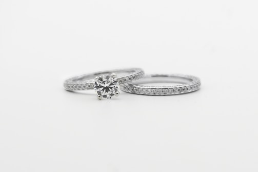 silver diamond studded ring on white surface