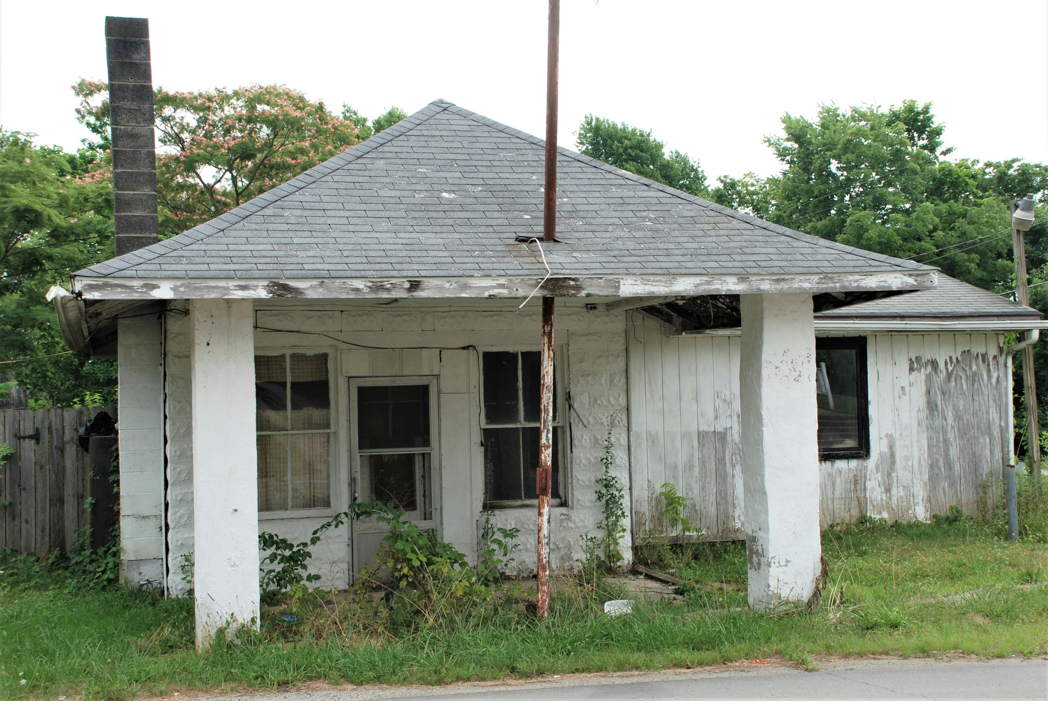 white wooden house with red metal pole