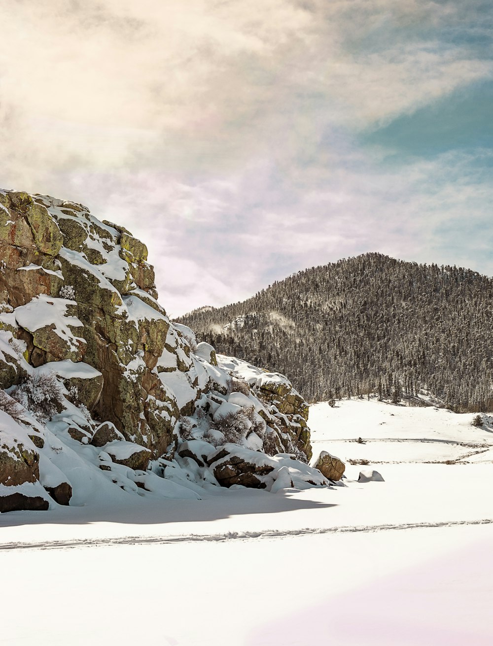 snow covered field and mountains during daytime