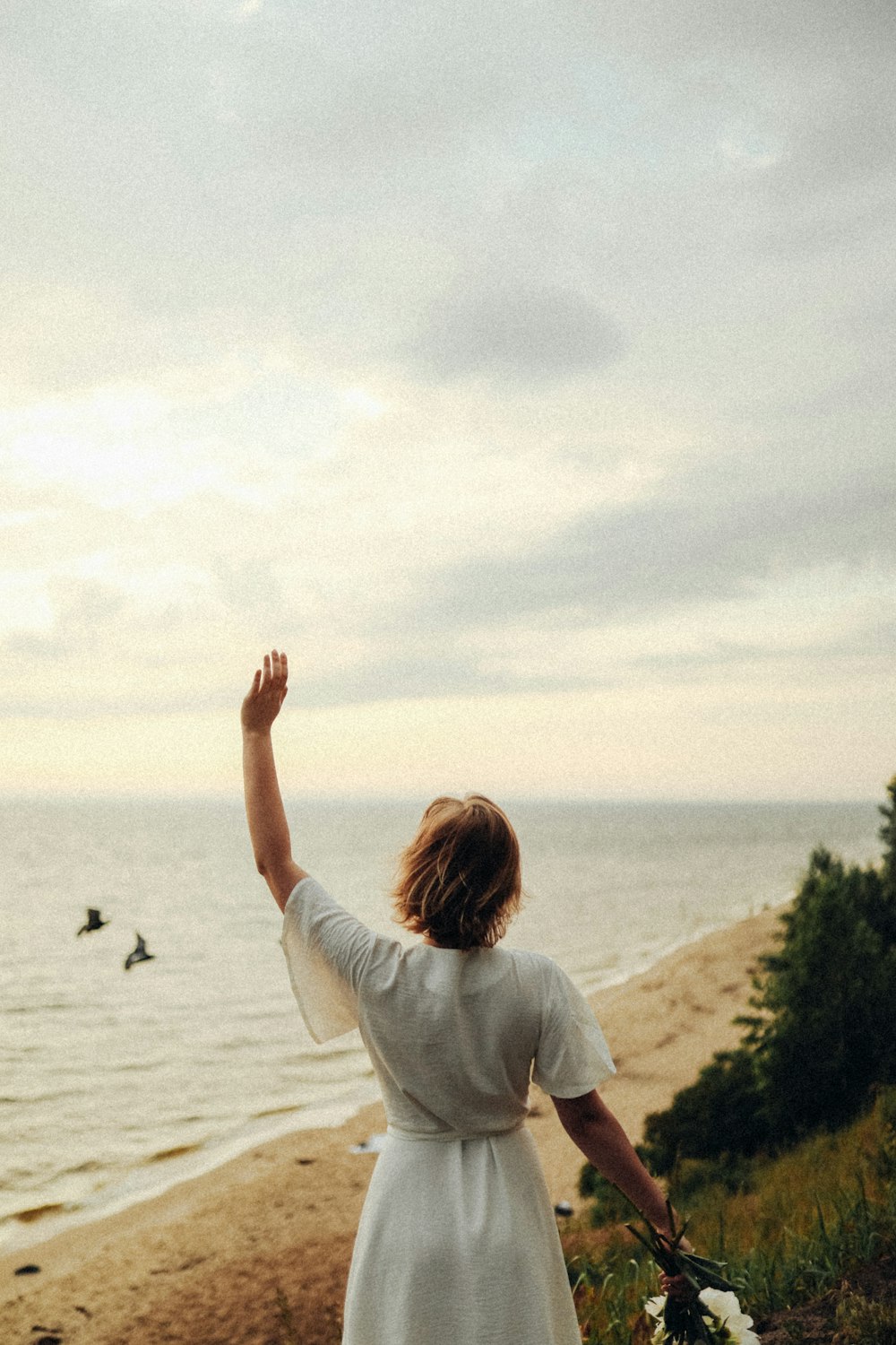 woman in white shirt raising her hands