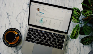 macbook pro beside white ceramic mug