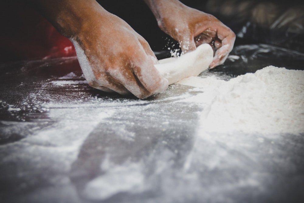 person holding white powder on gray table