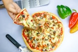 pizza with green bell pepper and cheese on white ceramic plate