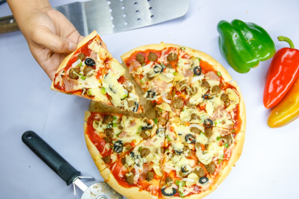 Pizza con pimiento verde y queso en plato de cerámica blanca