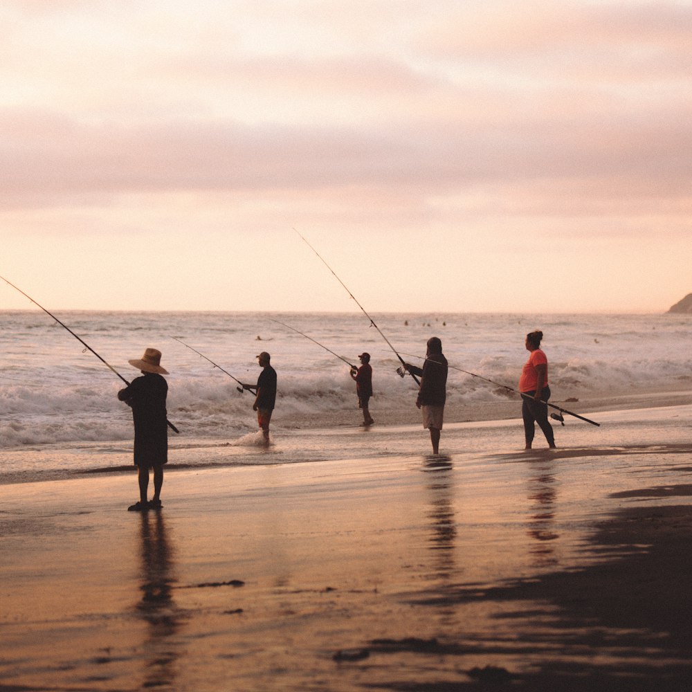 Gente pescando en la playa durante el día