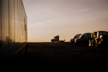 Fleet of trucks parked at a logistics terminal during sunrise.