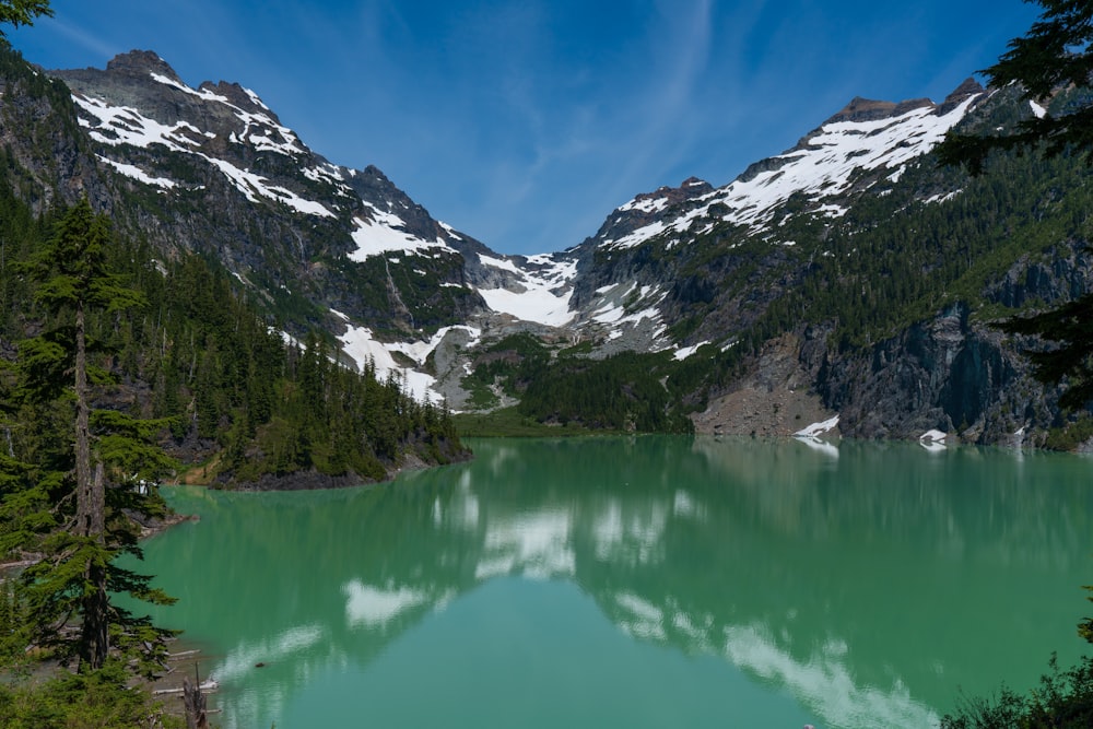 lac au milieu de la forêt et des montagnes enneigées