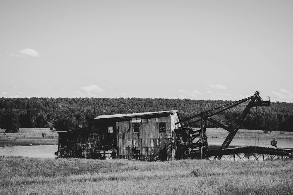 grayscale photo of wooden house on grass field