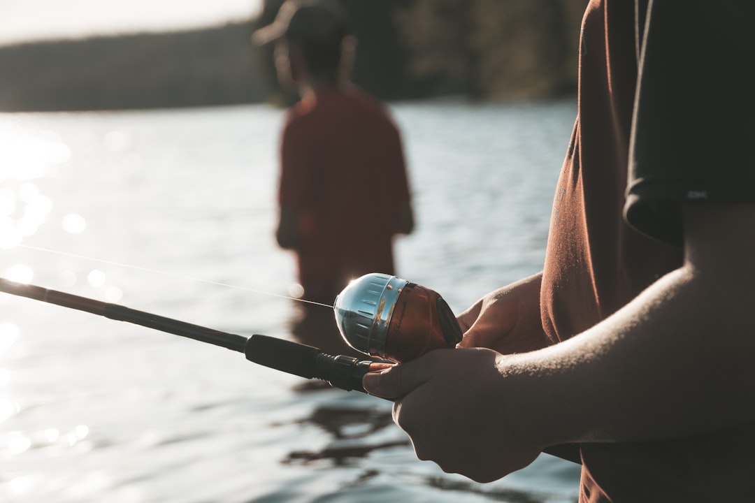 woman holding black and silver fishing rod