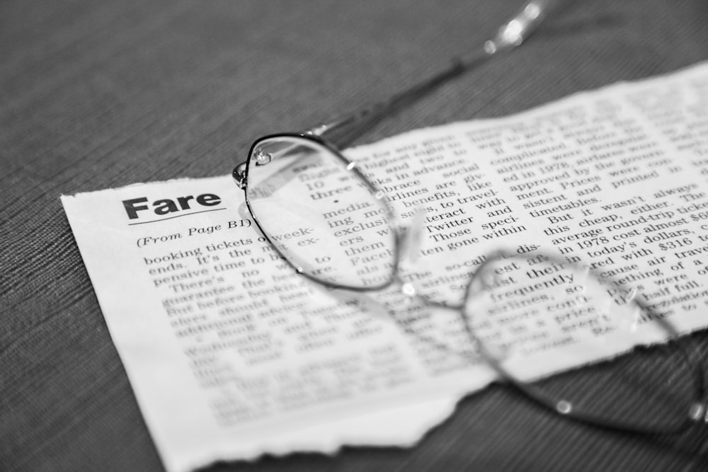 black framed eyeglasses on newspaper