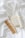 A white toothbrush with wooden handle, a brown wooden comb, a bar of soap with a minimalist label, and a bottle of body milk are neatly arranged on a soft, white fabric surface.