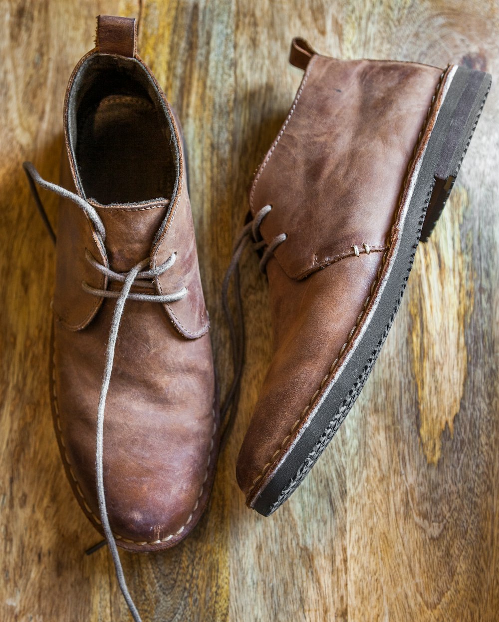 brown leather shoes on brown wooden surface