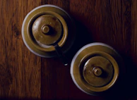 Close-up of elegant ceramic spice jars with silver lids on a dark wooden tray.