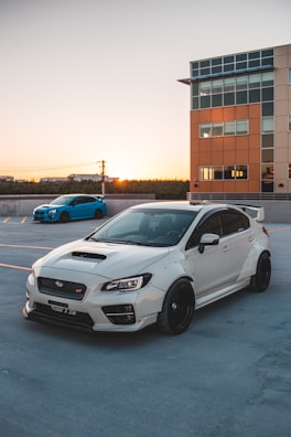 Side view of a sporty car featuring a tidparts body kit, parked on a city street at sunset.