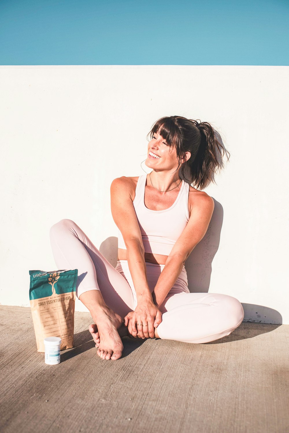 woman in white tank top sitting on brown wooden seat