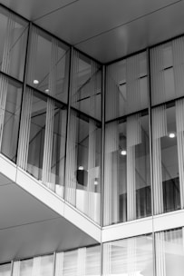 A modern glass door reflecting sunlight, set against a sleek contemporary building facade.