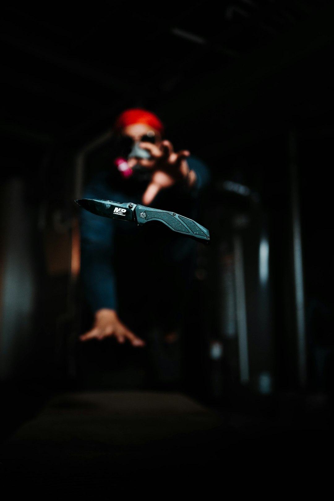 man in black and red mask holding black skateboard