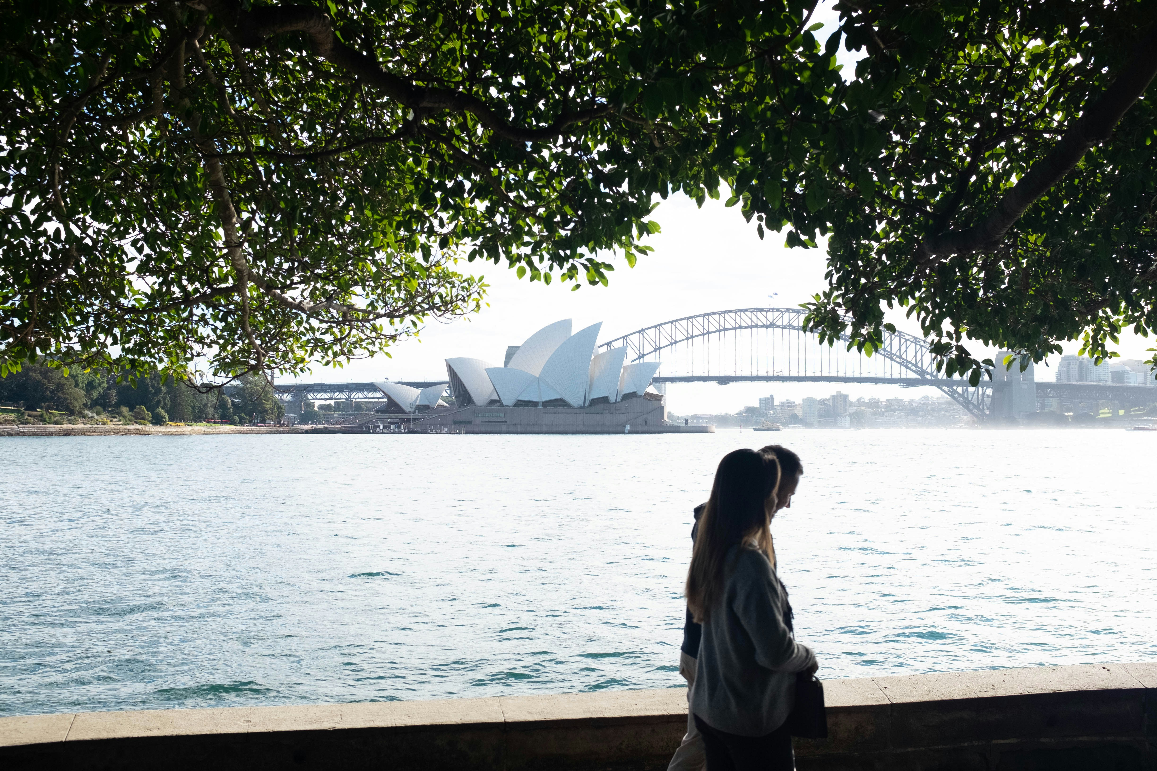 woman in white shirt standing near body of water during daytime