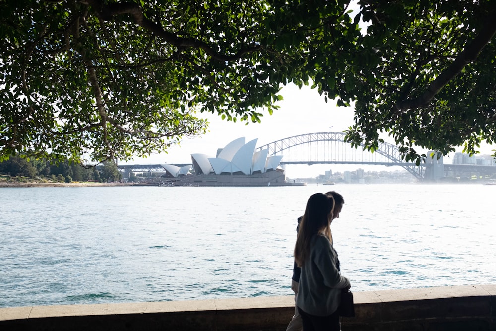 woman in white shirt standing near body of water during daytime