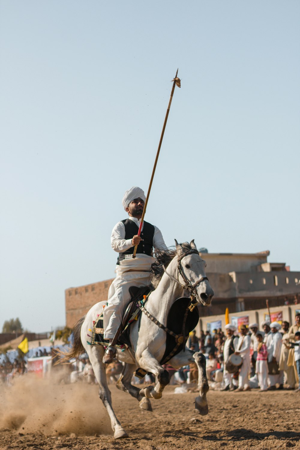 man in black and white suit riding white horse during daytime