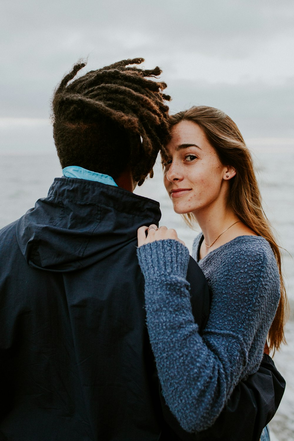 woman in blue long sleeve shirt beside woman in gray long sleeve shirt