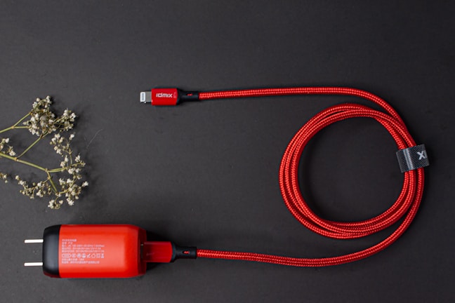 Close-up of a glossy black fast charging cable coiled neatly on a white surface with electric blue accents.