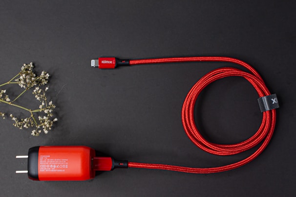 Tangled-free ghrprotect charging cables coiled neatly on a wooden desk beside a laptop.