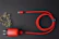 A neatly coiled electric blue charging cable resting on a sleek white desk with subtle glassmorphism effects.