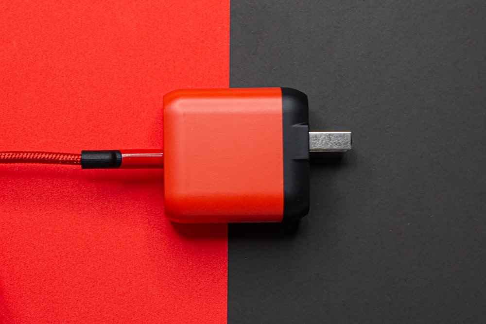 red and black adapter on red table