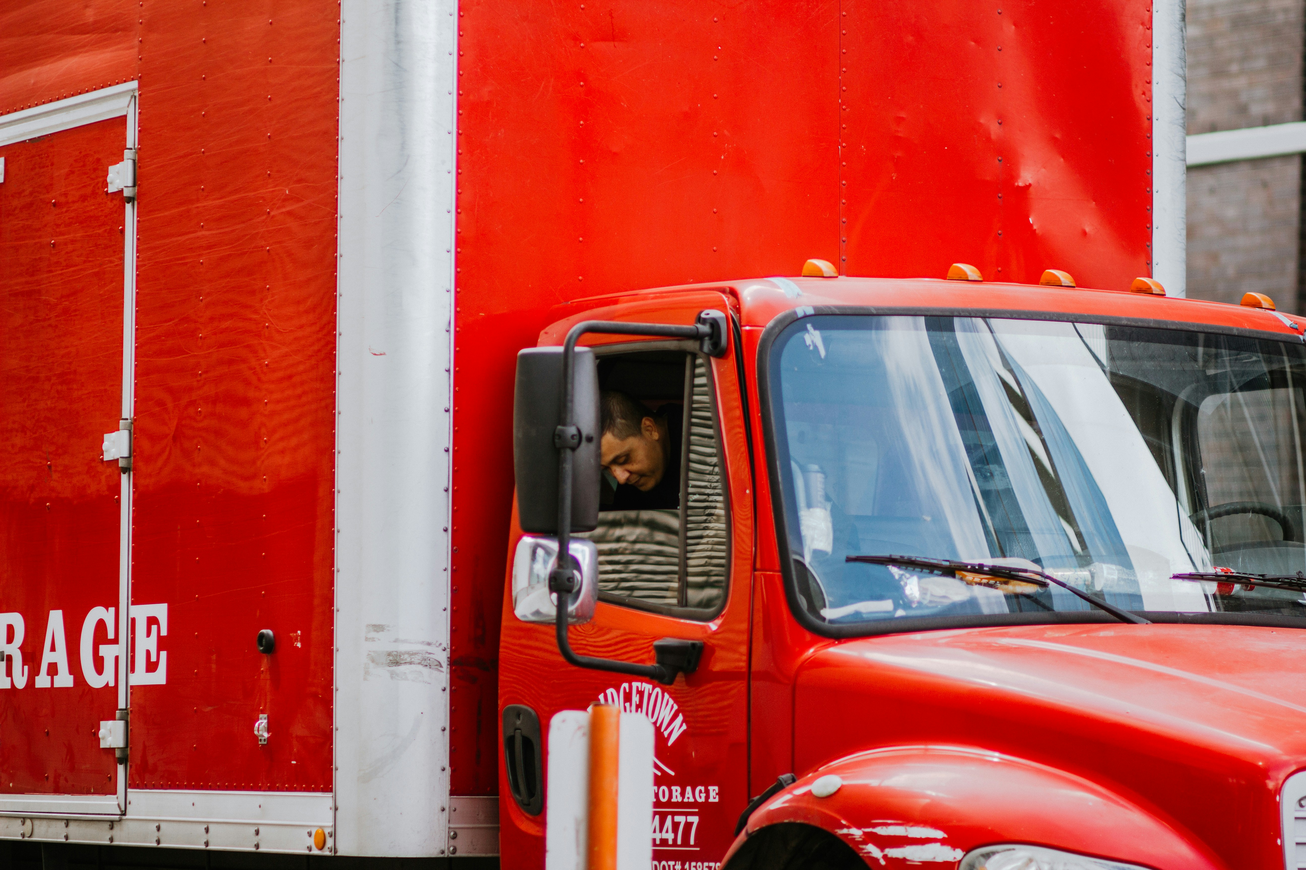 red and white truck in front of orange wall