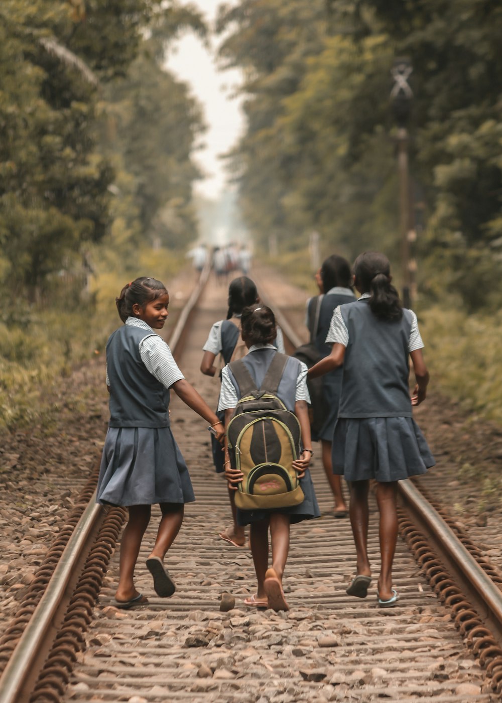 people walking on train rail during daytime