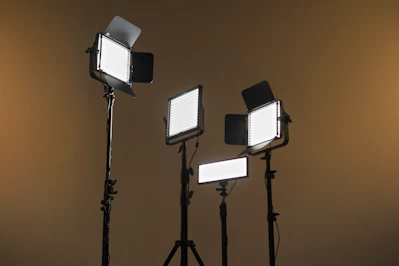 A set of Aputure lights arranged on a film set, glowing warmly in a dim studio.