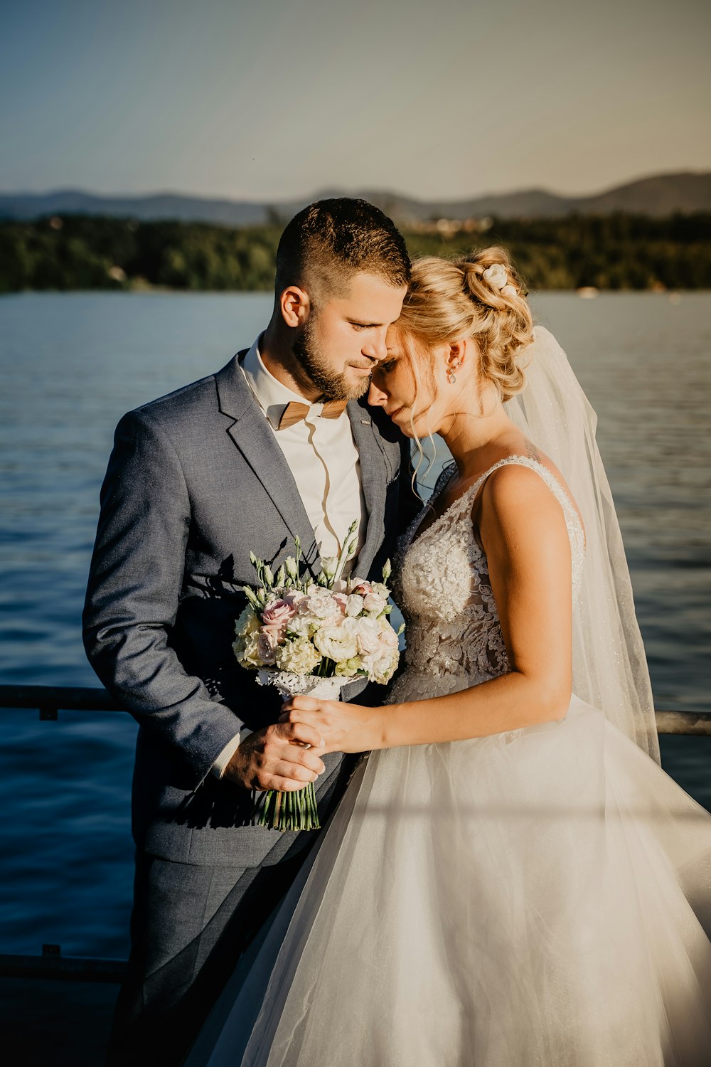 man in black suit kissing woman in white wedding dress