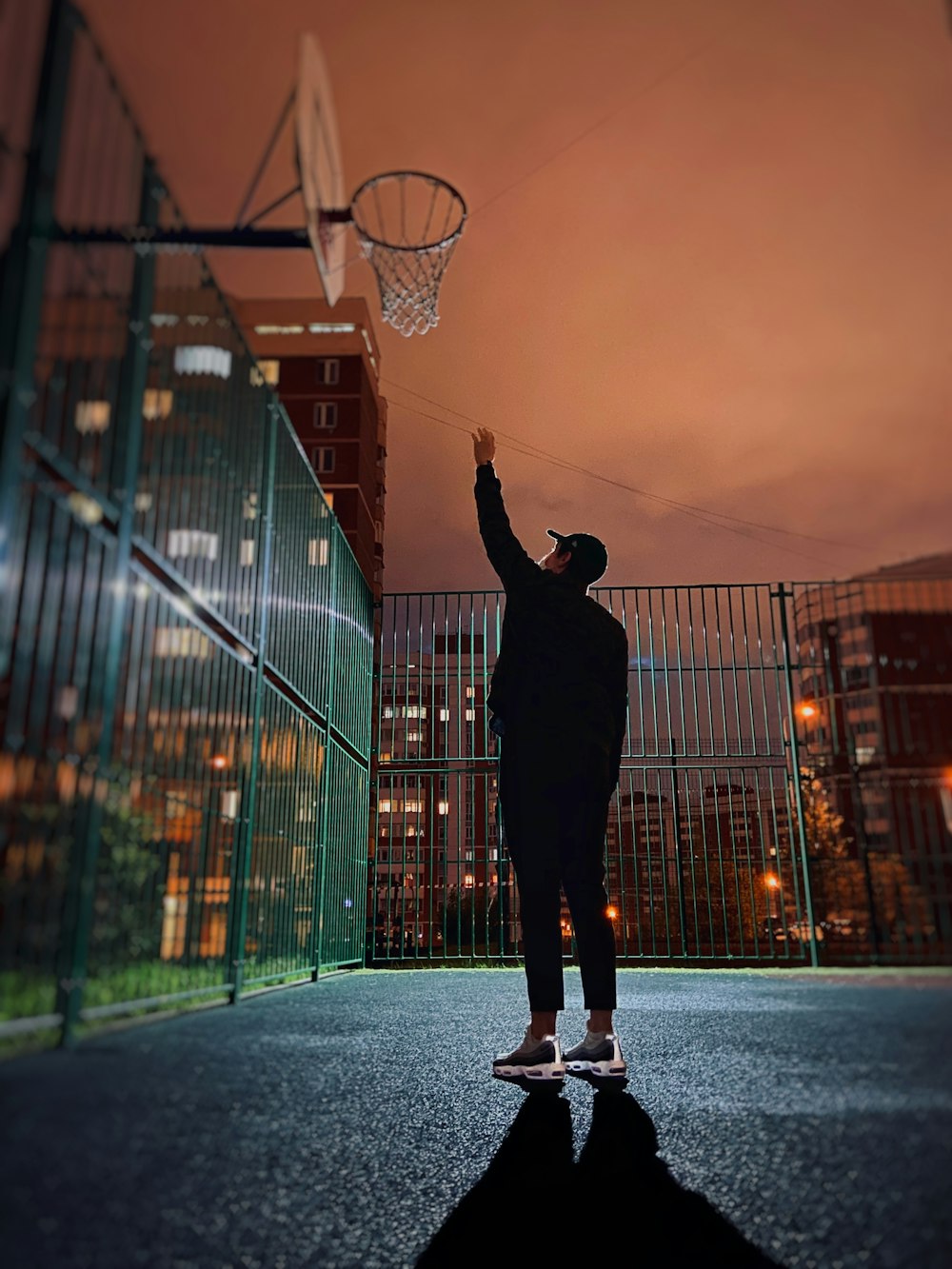 silhouette of man playing basketball during sunset
