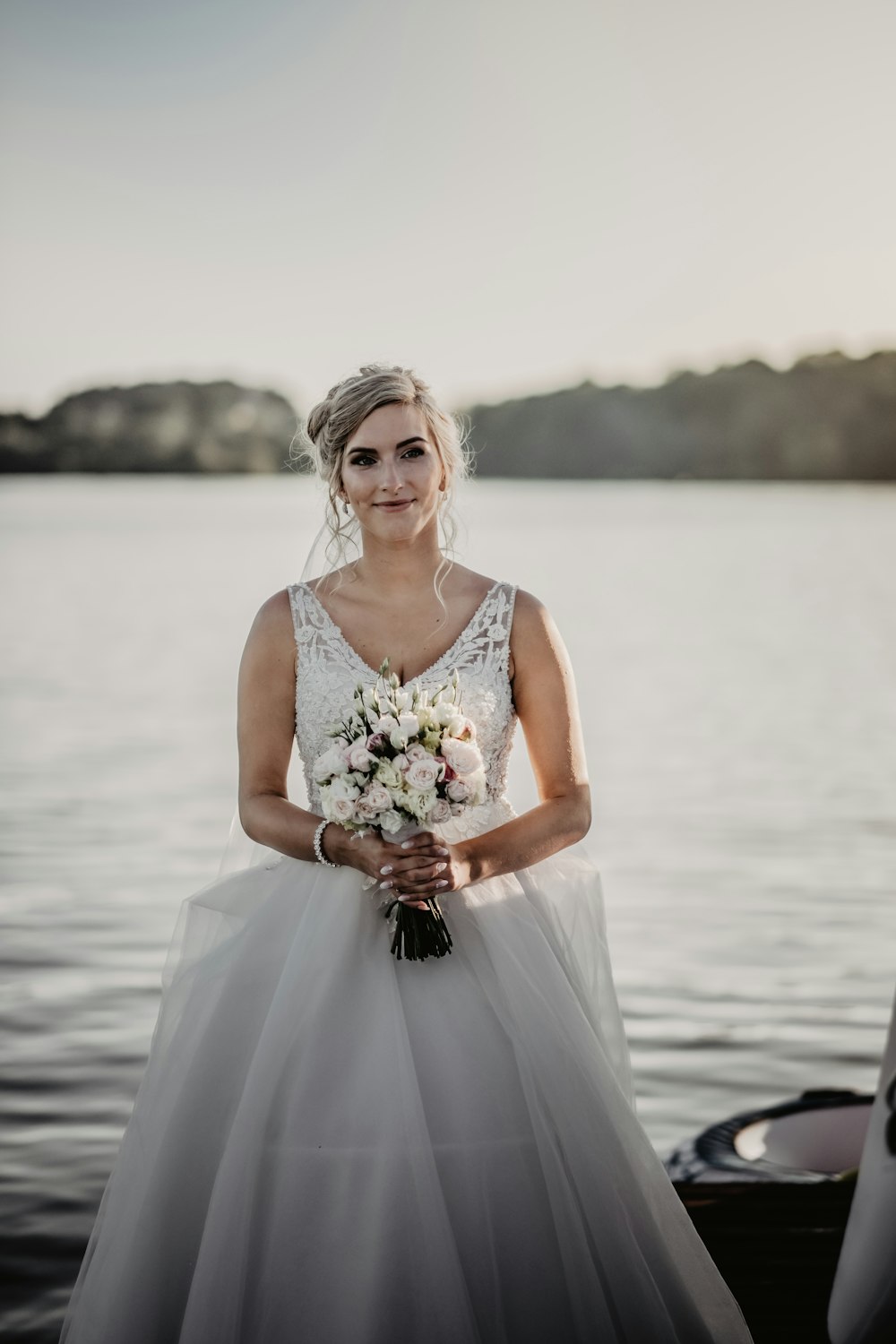 woman in white sleeveless dress holding bouquet of flowers