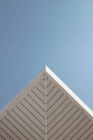 The sharp edge of a rooftop against a pale sky, the composition balanced and serene.