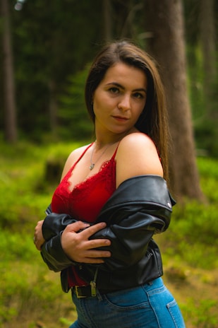 Close-up of detailed Lara Croft costume with weathered leather and gear in a forest setting.