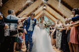 bride and groom standing beside brown wooden wall