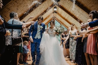 bride and groom standing beside brown wooden wall