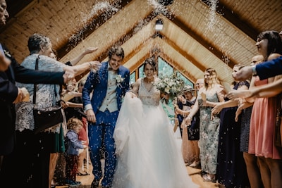 bride and groom standing beside brown wooden wall