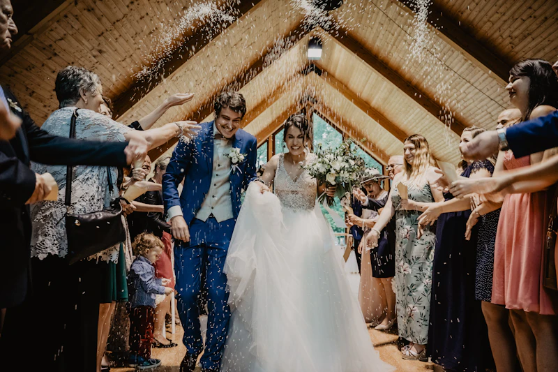 Bride and groom standing together beside a wooden wall at their wedding venue