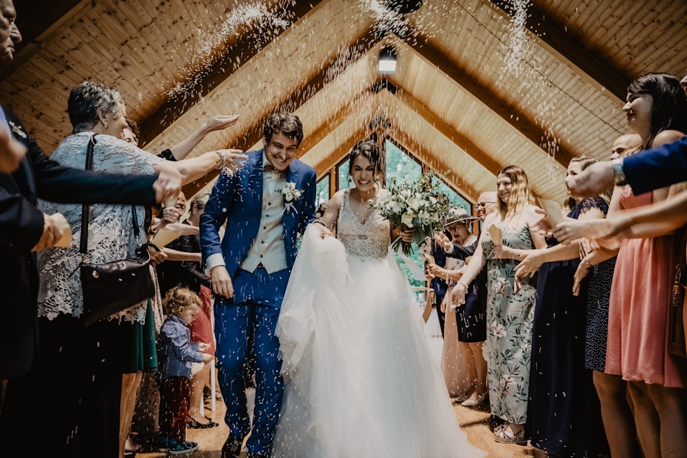 bride and groom standing beside brown wooden wall