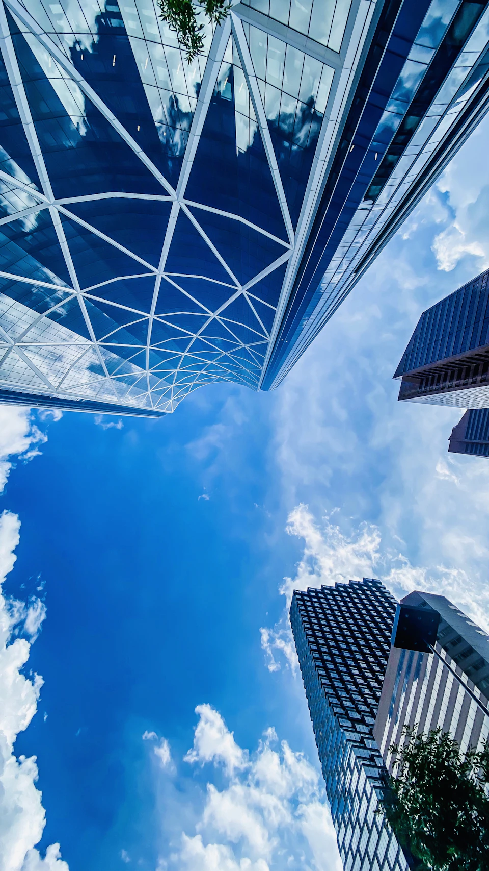 Three modern and traditional buildings stand together in cityscape under clear blue sky