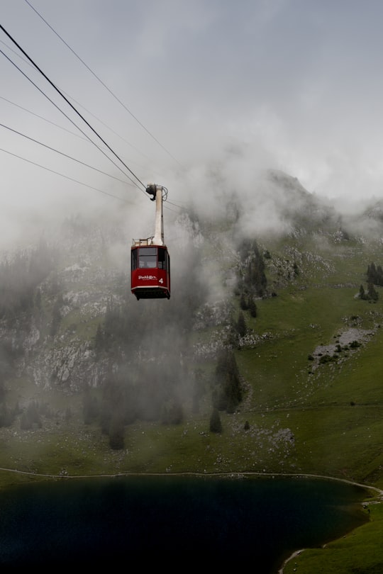 red cable car over green mountain in Hinderstockesee Switzerland