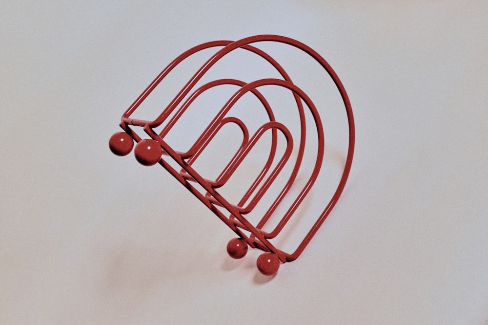 a red metal object on a white surface