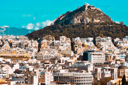 city buildings near mountain under blue sky during daytime