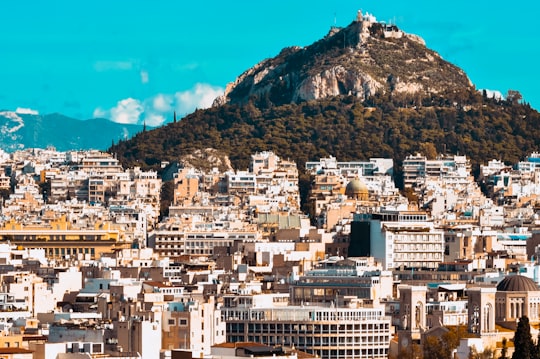 city buildings near mountain under blue sky during daytime in Acropolis of Athens Greece