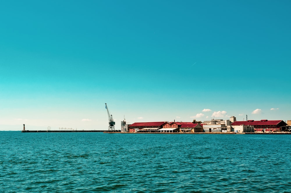 red and white ship on sea under blue sky during daytime